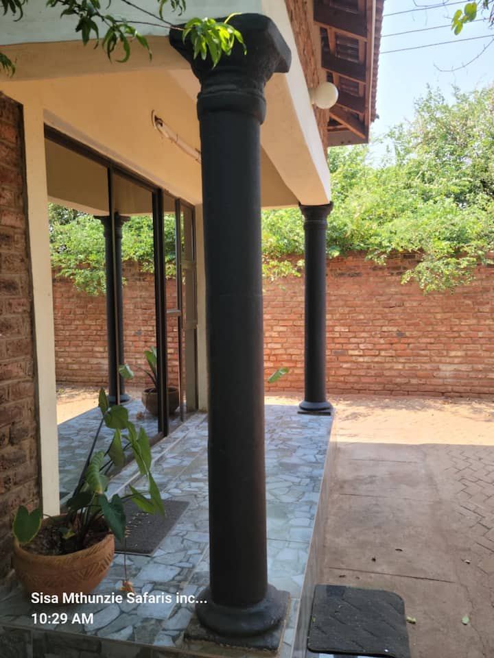 Shaded verandah and garden wall outside Granadilla Cottage, Aerodrome, Victoria Falls