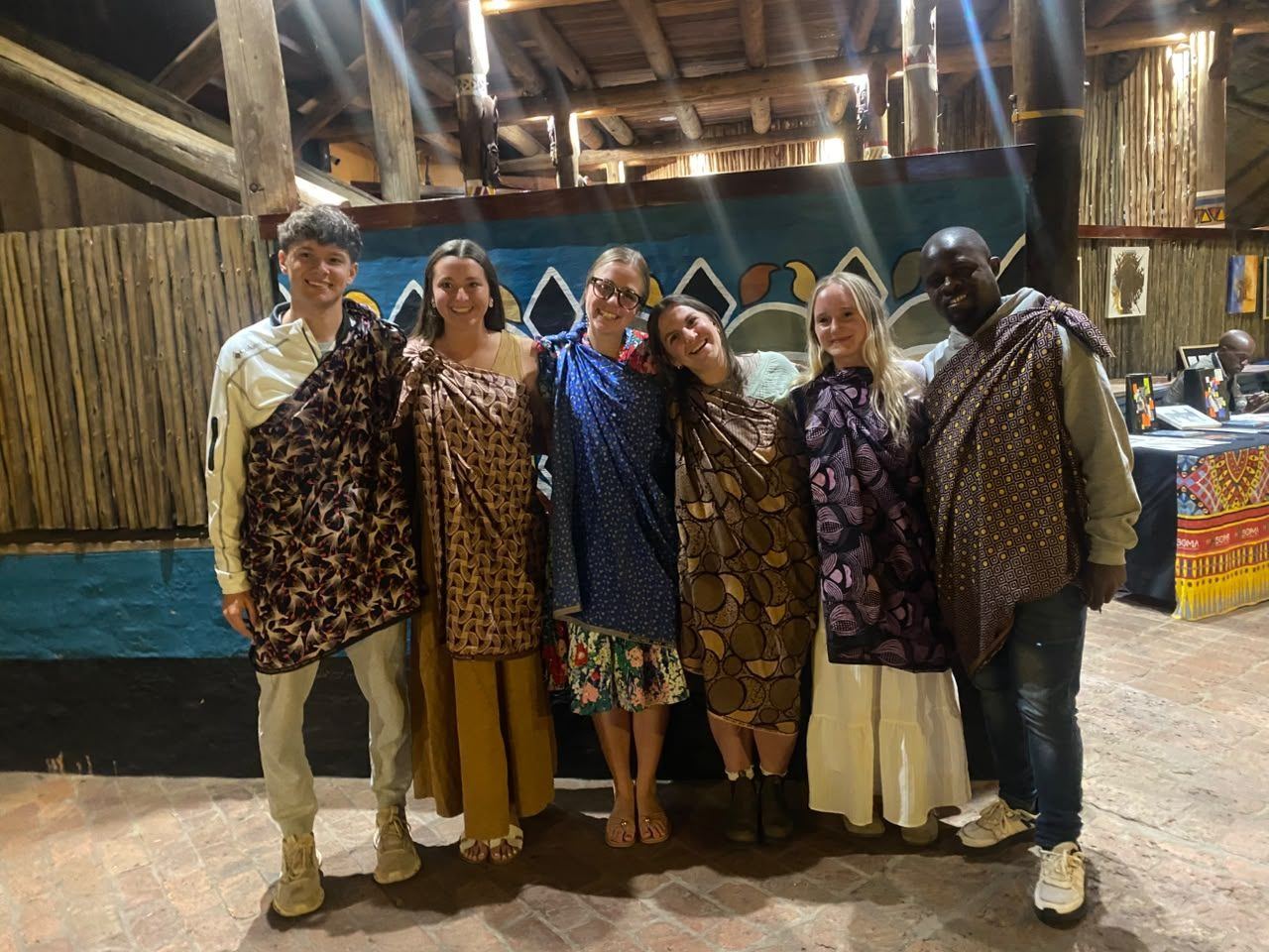 Guests wrapped in Zimbabwean printed fabrics at a cultural evening