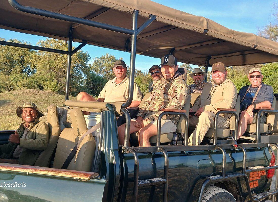Guests seated in an open game viewer under a canopy in Hwange