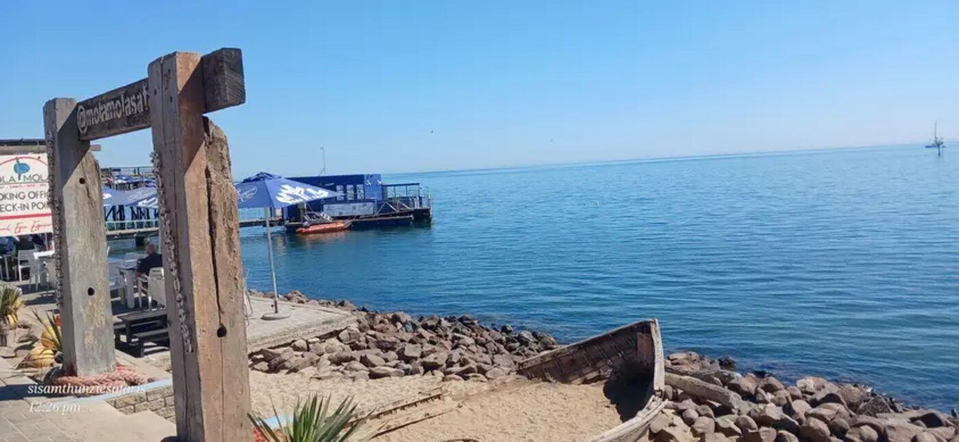 Wooden jetty and moored boat on a calm Indian Ocean shoreline